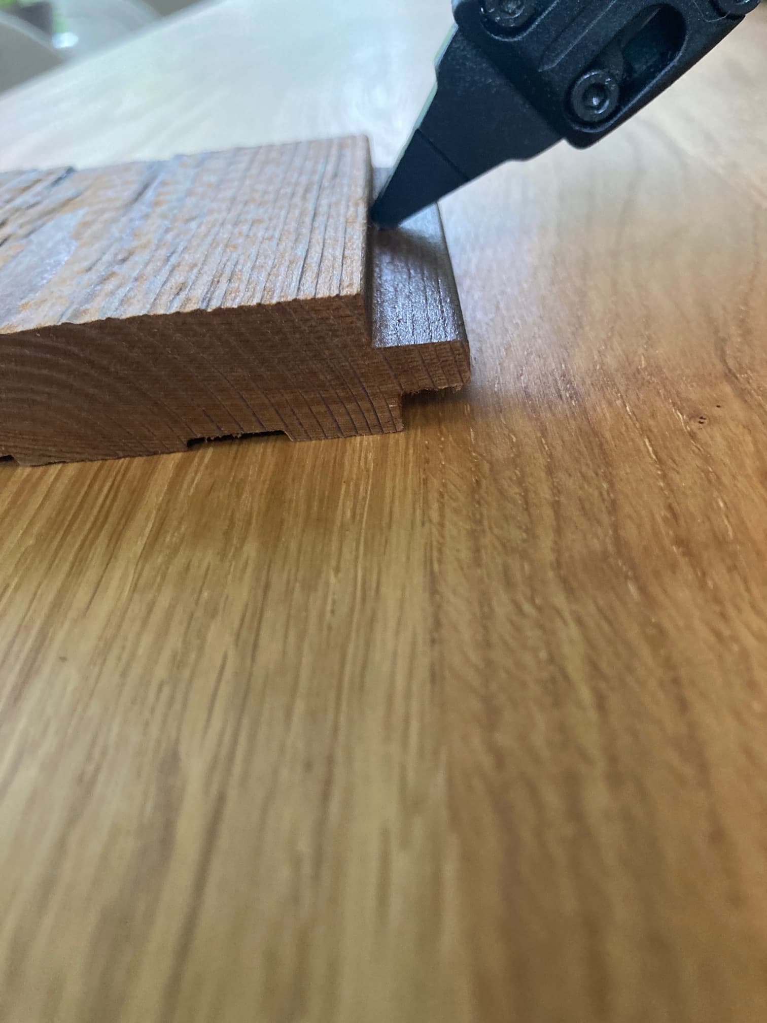 Nail gun positioned at a 45 degree angle through the tongue edge